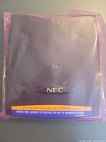 Front view of sealed NEC CD-ROM module showing NEC logo and caution sticker