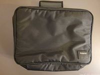 Front view of black nylon Polaroid camera bag showing logo patch and exterior condition