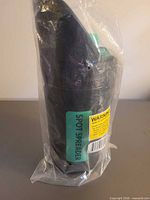 Full view of sealed spot spreader in plastic bag, showing body and labels