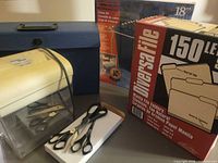 Group view showing shredder, file folders box, blue file case, Pendaflex frame kit package, scissors
