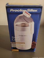 Front of sealed box showing Proctor Silex Fresh Grind coffee grinder