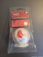 Front view of Rawlings Boston Red Sox collectible baseball in clear packaging showing logo and inscription