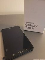 Tablet front view beside branded box