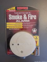 Front view of sealed Kidde Nighthawk smoke & fire alarm package showing product and battery