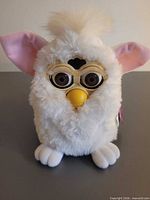 Front view of white Furby showing facial features and overall condition