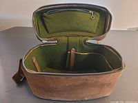 Open case showing green felt interior, dividers and zip pocket