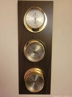 Full view of three-gauge Springfield weather station on wood panel