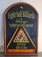 Full view of arched wall sign with text, frame, cues, triangle rack and 8-ball emblem