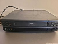 Front view of Zenith VR4125 VHS player showing cassette slot and attached power cord
