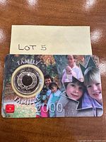 Full view of presentation card showing coin and family imagery