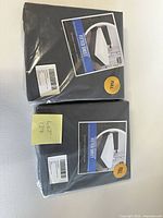 Two sealed grey fitted sheet packages