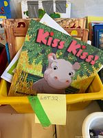 Front view of yellow bin filled with children’s books, Kiss Kiss! cover visible