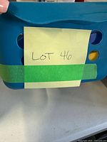 Blue perforated plastic bin front with lot note