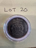 Front view of encapsulated Canadian 1952-2002 50-cent coin showing coat of arms and inscriptions