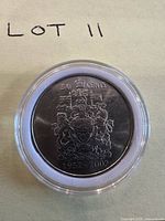 Full view of coin reverse in capsule showing coat of arms and date
