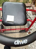 Close-up of black padded seat, basket and Drive logo on backrest