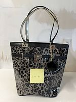 Front view of Guess leopard print patent tote with pom-pom