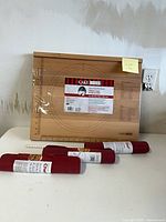 Overall view of beechwood pie board in plastic wrap with three rolled silicone sheets