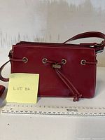 Front view of red purse next to ruler