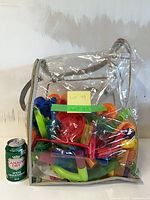 Full view of clear zippered bag filled with marble run pieces; soda can for scale