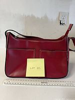 Front view of red leather Baci purse with ruler for scale