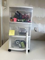 Front view of 3-drawer cart with contents visible and ruler for scale