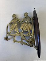 Overall view of brass Dutch figures on oak backboard