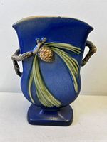 Front view of blue Roseville Pinecone vase showing pinecone relief and twig handles