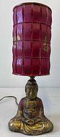 Full view of lamp showing Buddha base and red slat shade