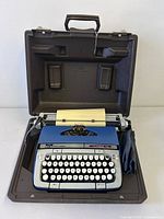 Typewriter in open carrying case showing keyboard and carriage