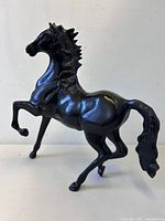 Full side view of black metal rearing horse statue