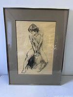 Full view of framed nude sketch under glass