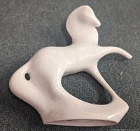 Full view of white porcelain abstract horse lying on side