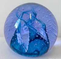 Front view of spherical purple-blue Caithness Cauldron paperweight showing internal swirl and bubbles