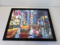 Front angled view of framed oil painting showing city night scene and taxis