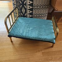 Brass bed with cushion angled view