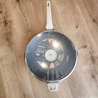 Top view of pan in shrink wrap with handle visible