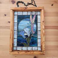 Full frontal view showing entire stained glass panel in wood frame with chain