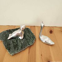Seal and swan figurines side by side