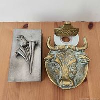 Overview of all three metal items: pewter matchbox cover, bull head dish, Coca-Cola opener