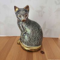 Front view of enameled brass cat figurine