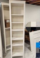 Front view of tall white Hemnes bookcase with six shelves