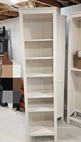Front view showing full height and shelves of white Hemnes bookcase