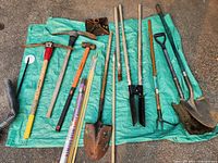 All yard tools laid out on green tarp