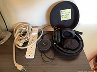 Overall lot with headphones in case, extension cord, power strip, Samsung charger
