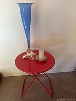 Table top with blue vase and candle for scale