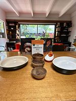 Front view of all items showing both dishes, three wood bowls, juicer and cookbooks