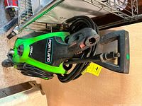 Full view of pressure washer upright showing hose, spray gun and power cord