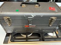 Closed gray Craftsman toolbox on stovetop