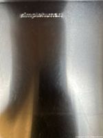 close-up of simplehuman logo on stainless steel surface